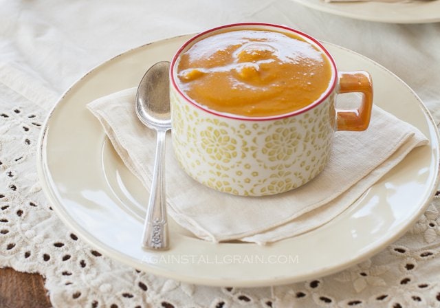 A steaming cup of traditional roasted pumpkin soup that is vegan and dairy free.