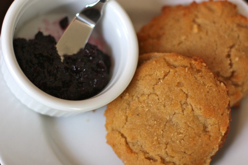 paleo honey biscuits on a plate with blueberry jam next to it with a spoon