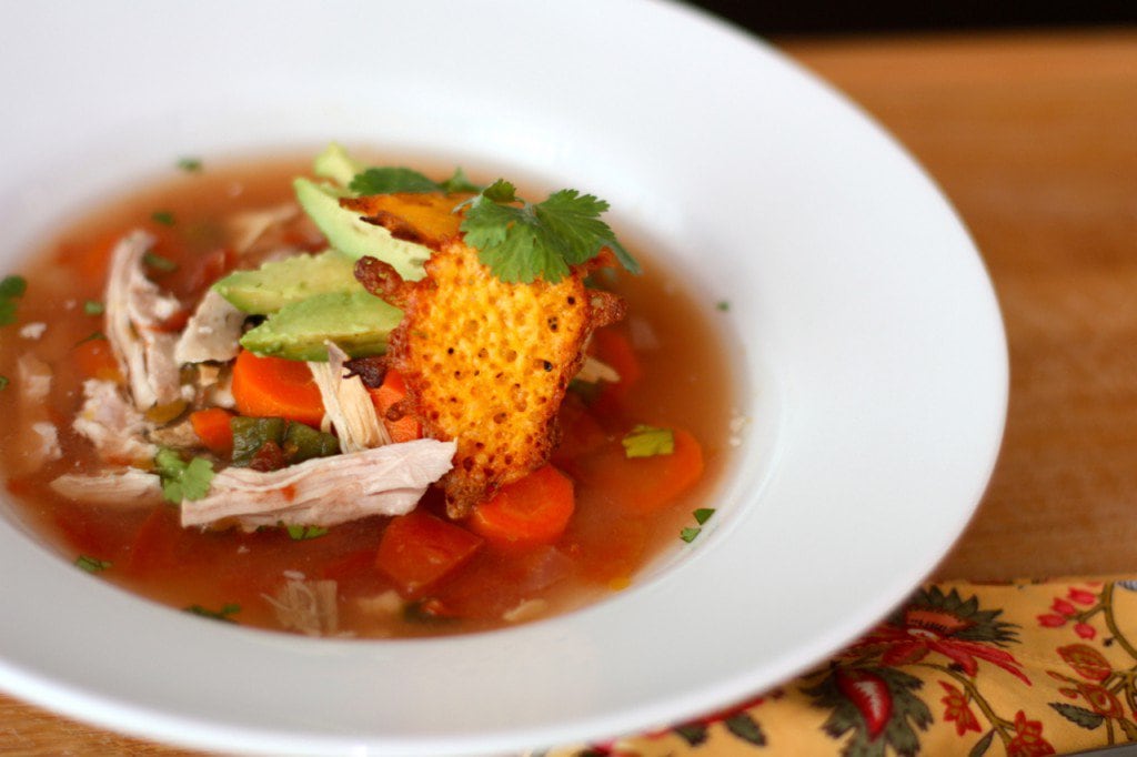 A steaming bowl of Crock Pot Mexican Chicken Soup with Cheddar Cheese Chips.