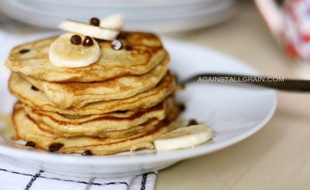 gluten free pancakes with bananas and butter on top and maple syrup.