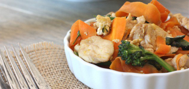 Paleo Pad See Ew in a small ceramic bowl on a placemat and with a fork next to it