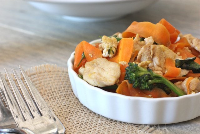 Paleo Pad See Ew in a small ceramic bowl on a placemat and with a fork next to it