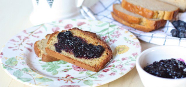 Homemade Blueberry Preserves without Pectin on grain free bread on a plate with two slices cut in the background