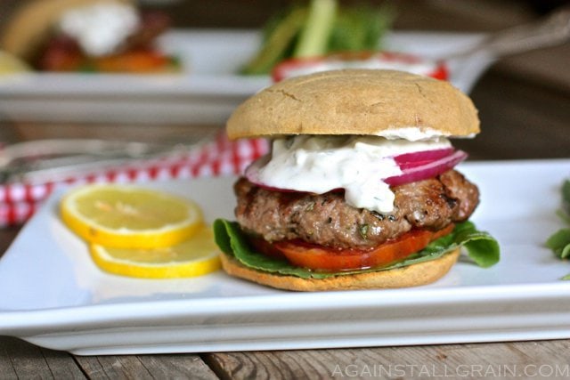 A Greek gyro burger topped with tomato, onion and a creamy cucumber yogurt sauce.