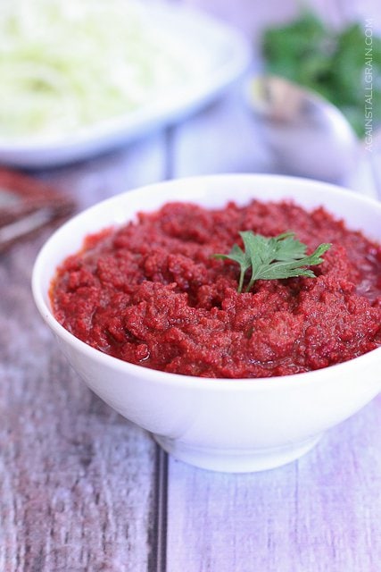 tomatoless  meat sauce in a white bowl with cilantro as a garnish on a wooden table