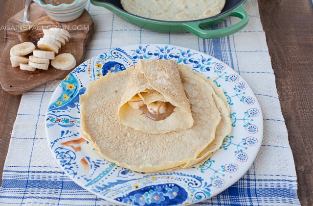 A plate of gluten free crepes filled with almond butter and bananas.