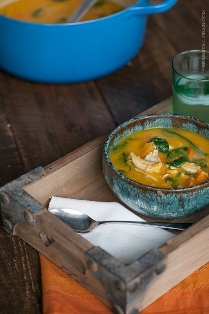 Roasted Chicken Soup in a rustic blue bowl set on a wooden tray on a wooden table