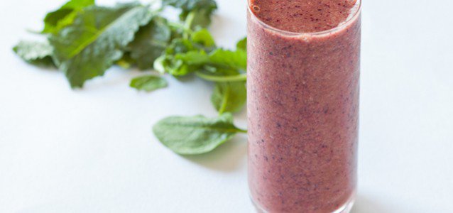 Green smoothie packed with blueberries, strawberries, bananas and leafy greens
