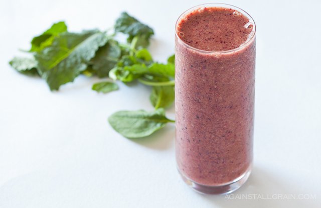 Green smoothie packed with blueberries, strawberries, bananas and leafy greens