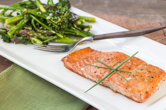 A plate of asian roasted salmon with a side of asparagus and brocollini.