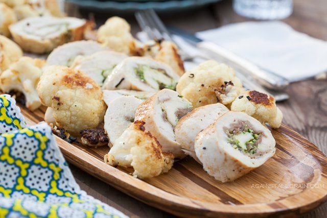 A bountiful plate of Prosciutto Pesto Chicken Roulade with a side of leeks and cauliflower.