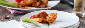 A plate of spicy chicken wings with dairy free ranch dressing.