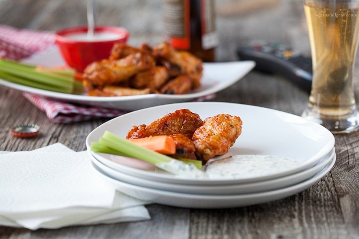 A plate of spicy chicken wings with dairy free ranch dressing.