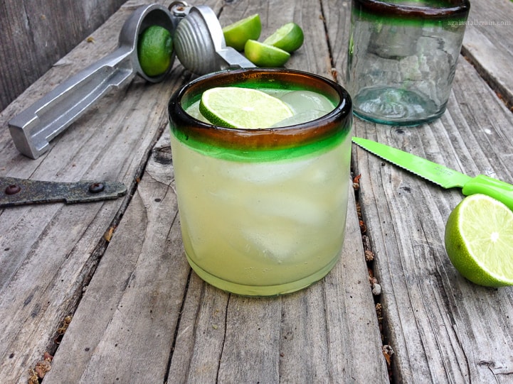 paleo margarias in a cup along with a fresh lime next to it