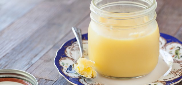 homemade ghee with a spoonful taken out and placed on a decorative plate