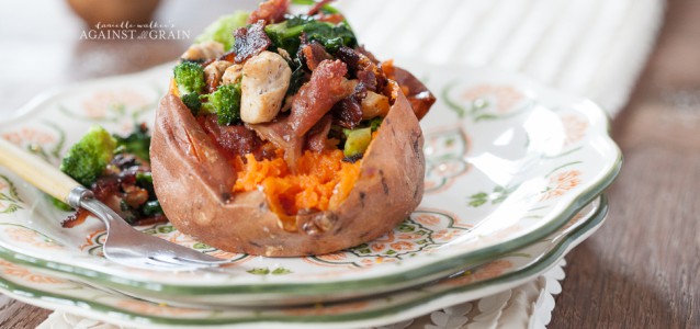 A delicious looking sweet potato stuffed with bacon, spinach, brussels sprouts, and chicken.