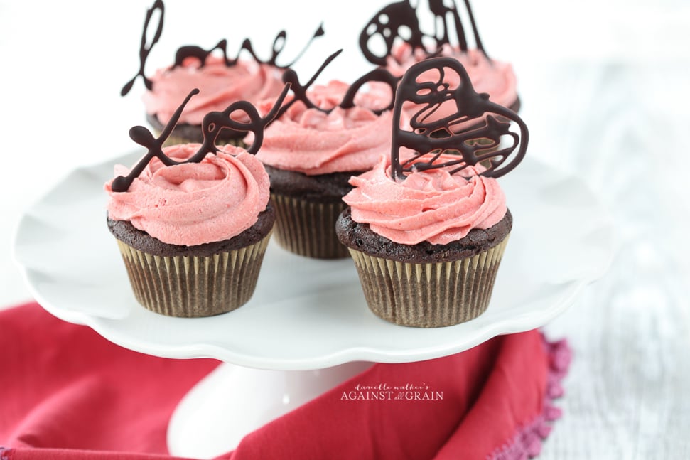 Beautifully decorated chocolate cupcakes with strawberry icing that are gluten and dairy free.