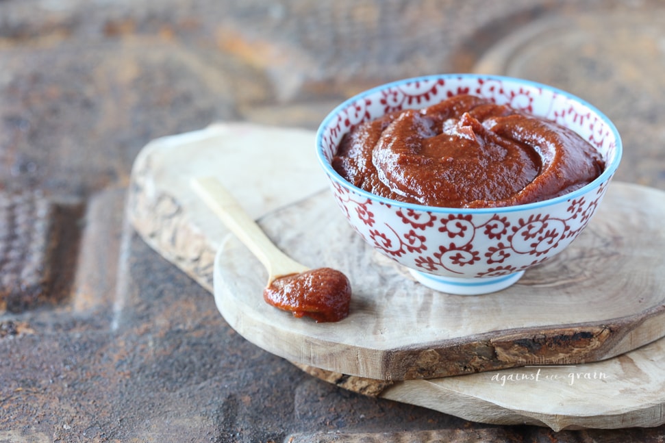 paleo bbq sauce in a dish on top of a cutting board