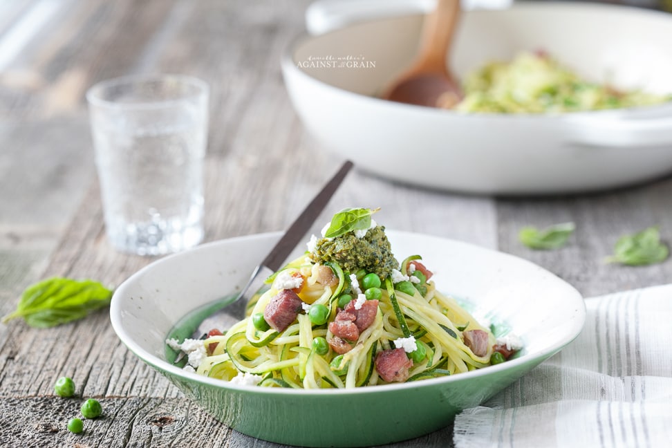 A delectable bowl of Spiralized Zucchini Pesto Pasta with Peas and Pancetta.