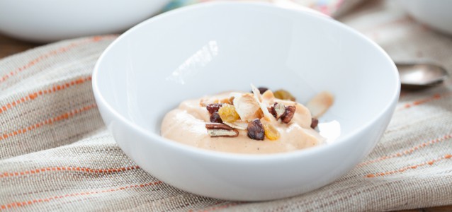 A bowl of dairy free carrot cake pudding topped with seeds and nuts.