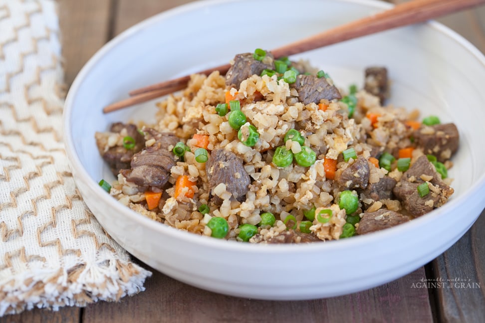 Cauliflower Fried Rice with Beef in a bowl and chopsticks placed into it