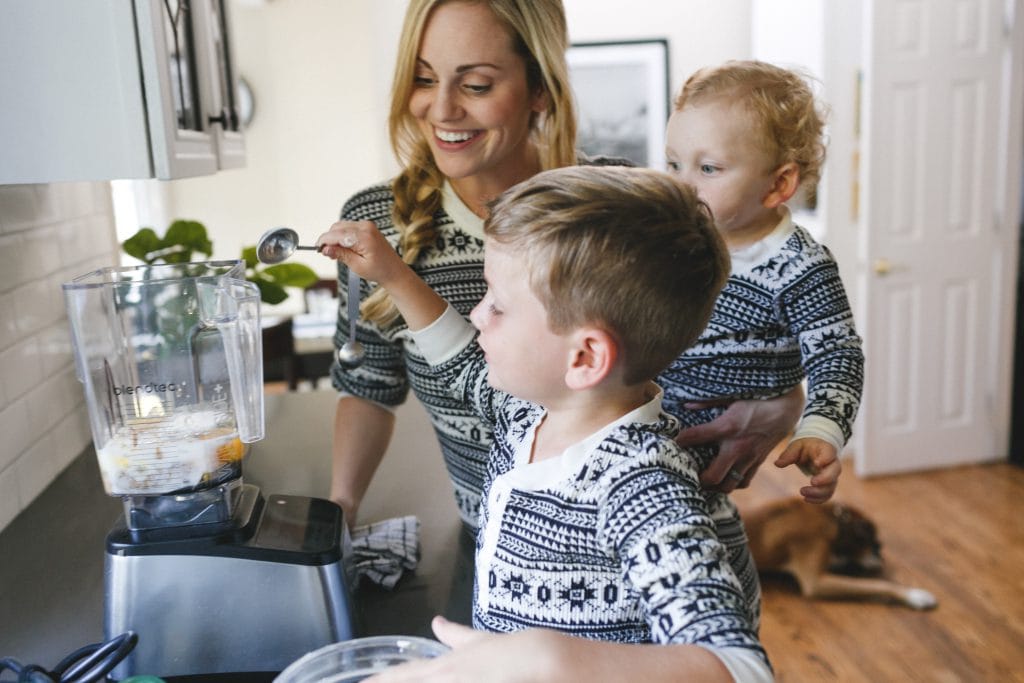 Danielle and her young boys making a batch of easy gluten free gingerbread waffles in a blender.