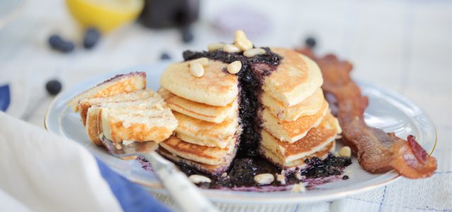 A stack of lemony gluten free pancakes topped with a blueberry sauce.