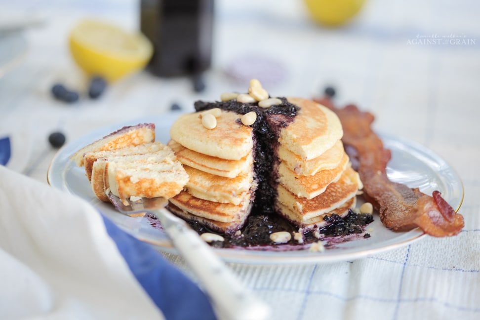 A stack of lemony gluten free pancakes topped with a blueberry sauce.