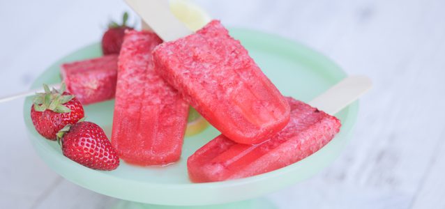 A plate of icy and delicious strawberry lemonade popsicles.