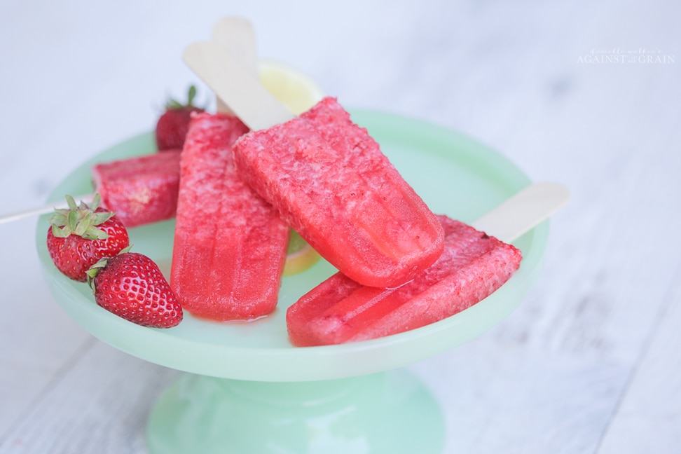 A plate of icy and delicious strawberry lemonade popsicles.