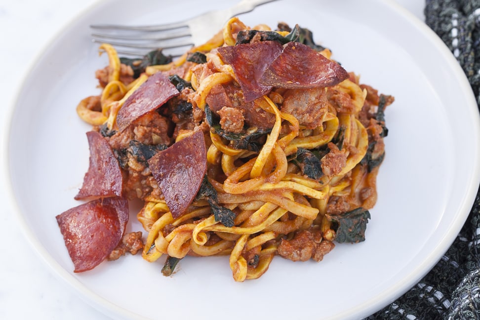 Pepperoni Pizza Pasta on a white plate with fork