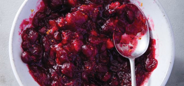paleo cranberry sauce in a white bowl with a silver spoon