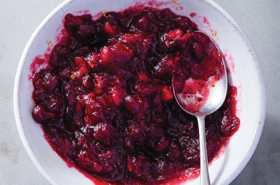 paleo cranberry sauce in a white bowl with a silver spoon