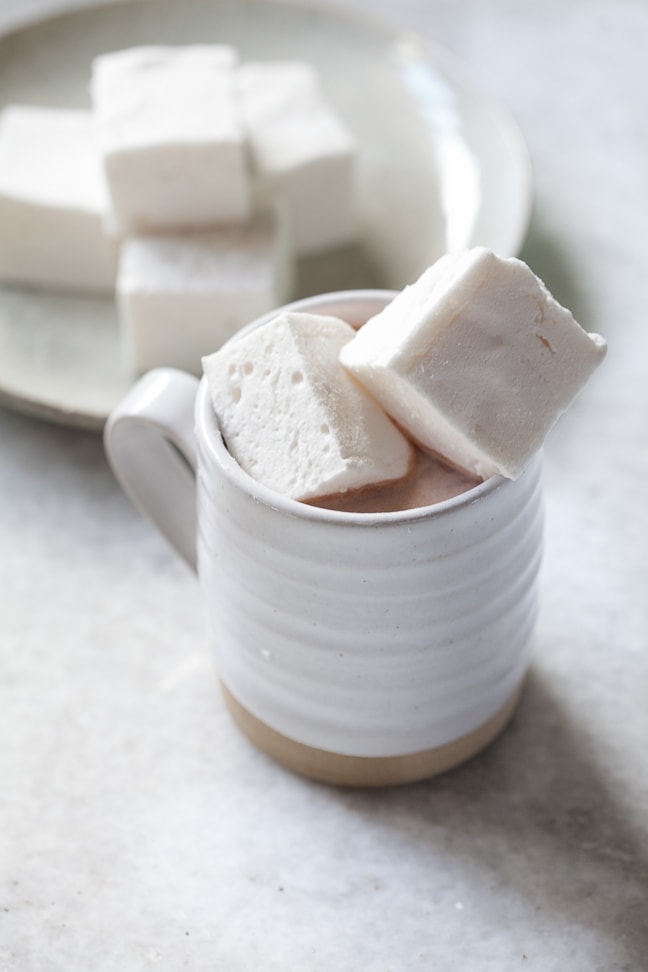 hot chocolate in a white cup topped with gluten-free marshmallows