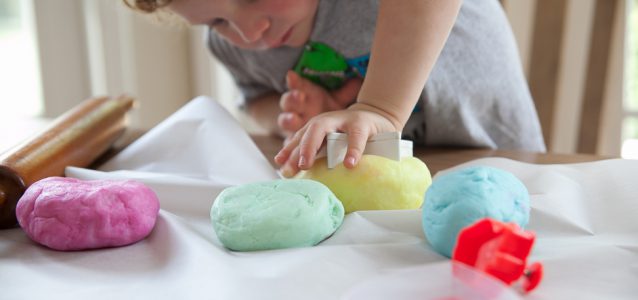child making Natural Gluten Free Play Dough into shapes using a cookie cutter