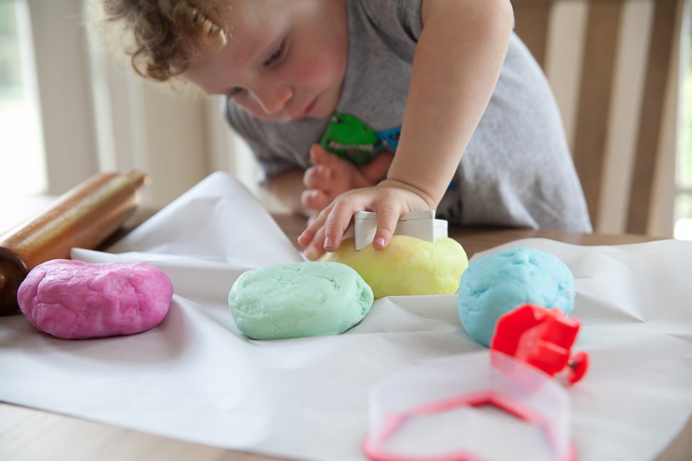 child making Natural Gluten Free Play Dough into shapes using a cookie cutter