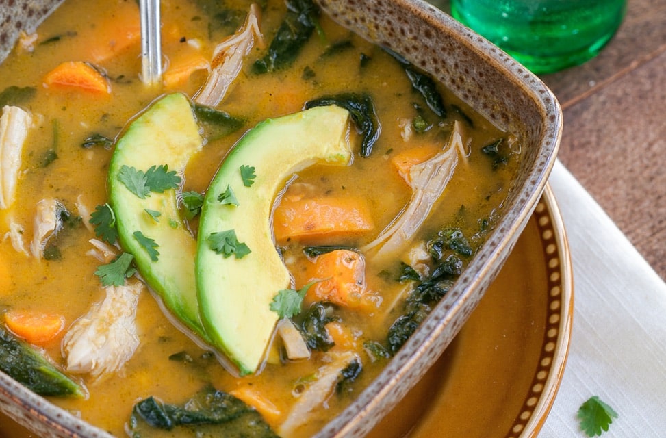 A steaming bowl of Instant Pot Mexican Chicken soup topped with avocado and cilantro.