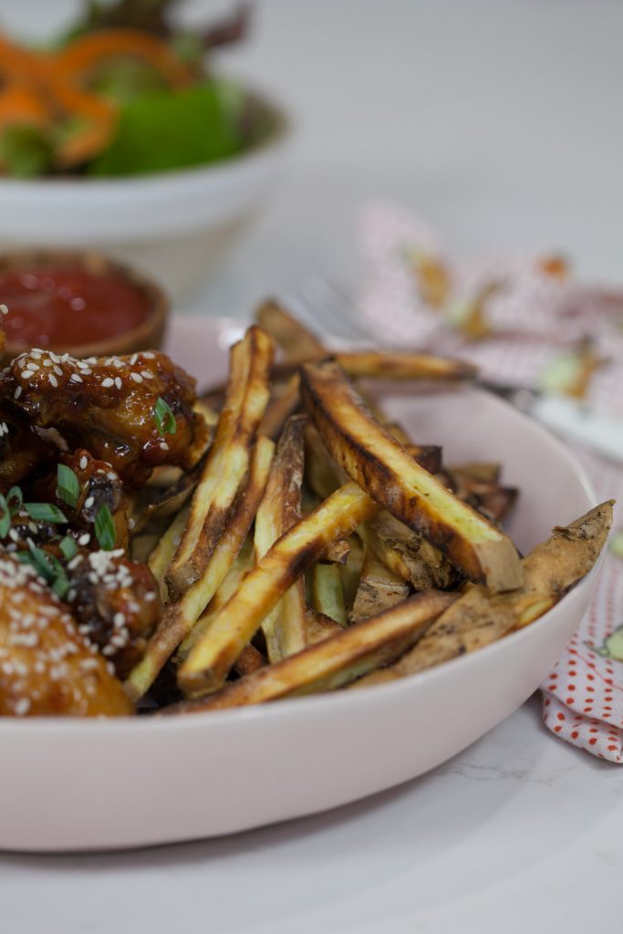 Sticky Sesame Chicken Wings with french fries in a white plate