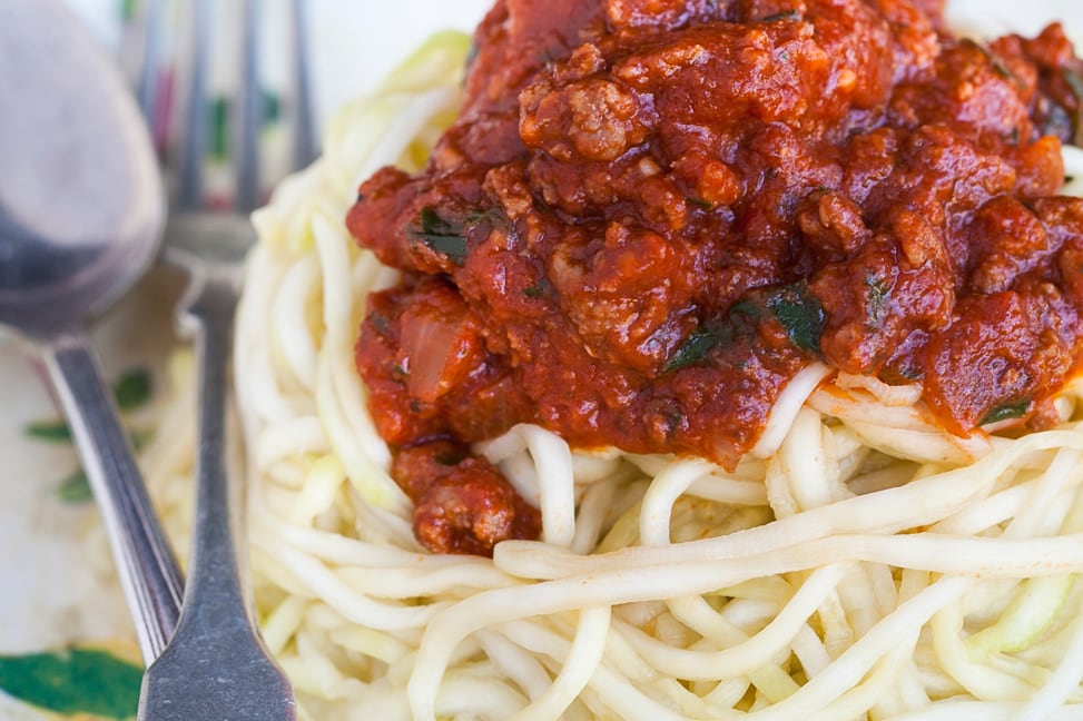 instant pot spaghetti sauce on top of squash noodles with a fork next to it