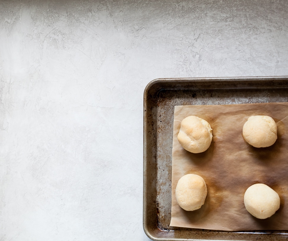 gluten free Brazilian cheese bread on a sheet pan just coming out of the oven