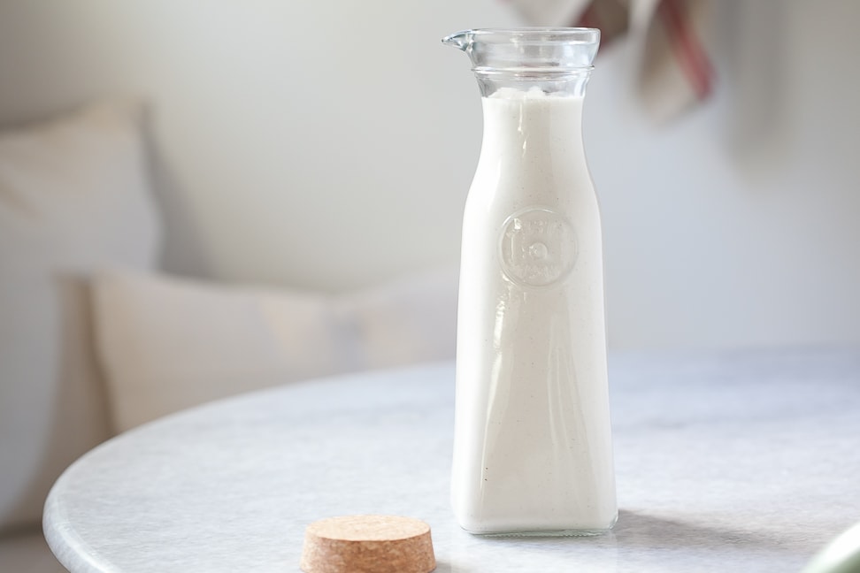 dairy free vanilla coffee creamer in a tall jar on a marble table