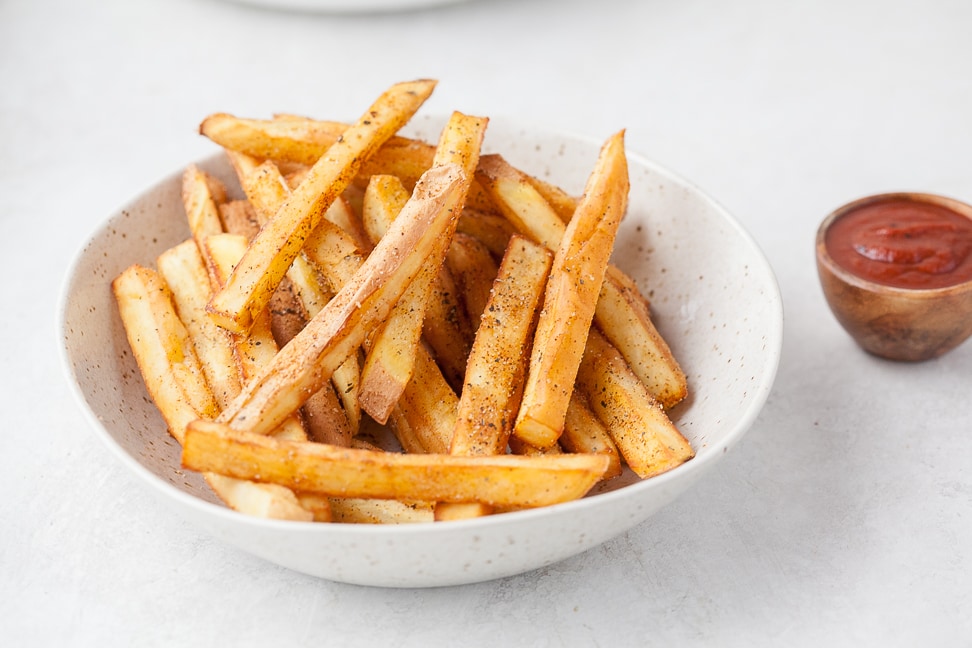 seasoned fries in a bowl with paleo bbq sauce next to them