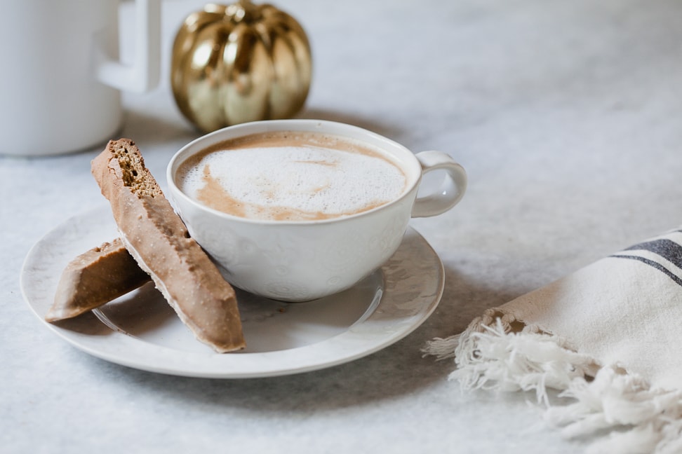 gluten free biscotti next to a latte in a white cup