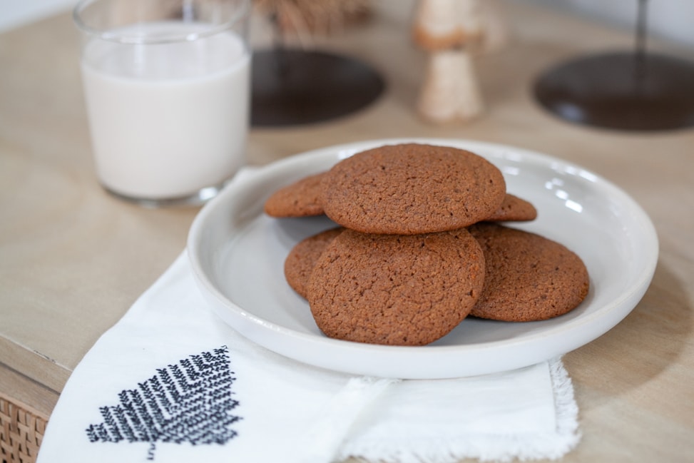 gluten free ginger molasses cookies on plate with a glass of almond milk