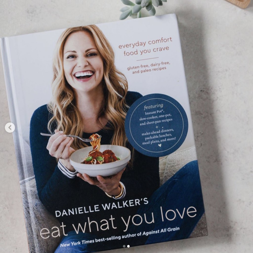Eat What You Love book, cover photo is of woman smiling at camera while eating a bowl of pasta