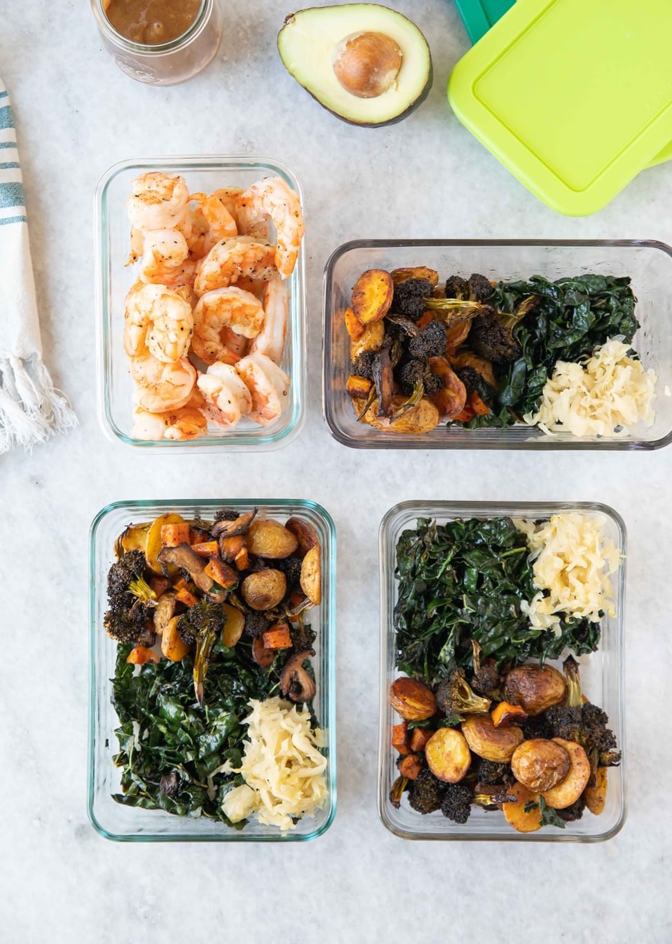 Roasted veggie bowls and a bowl of cooked shrimp displayed on a white marble counter