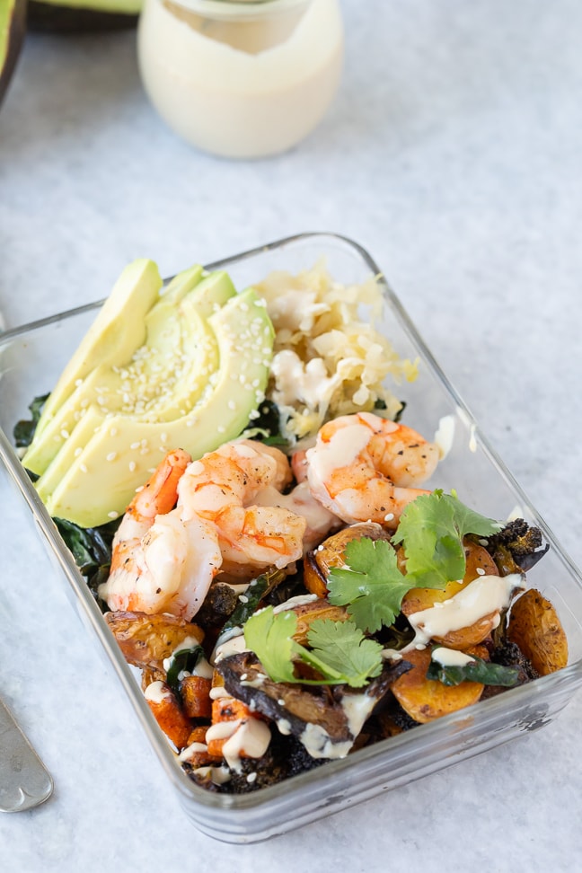 roasted veggie bowl topped with fresh avocado, cooked shrimp and homemade dressing