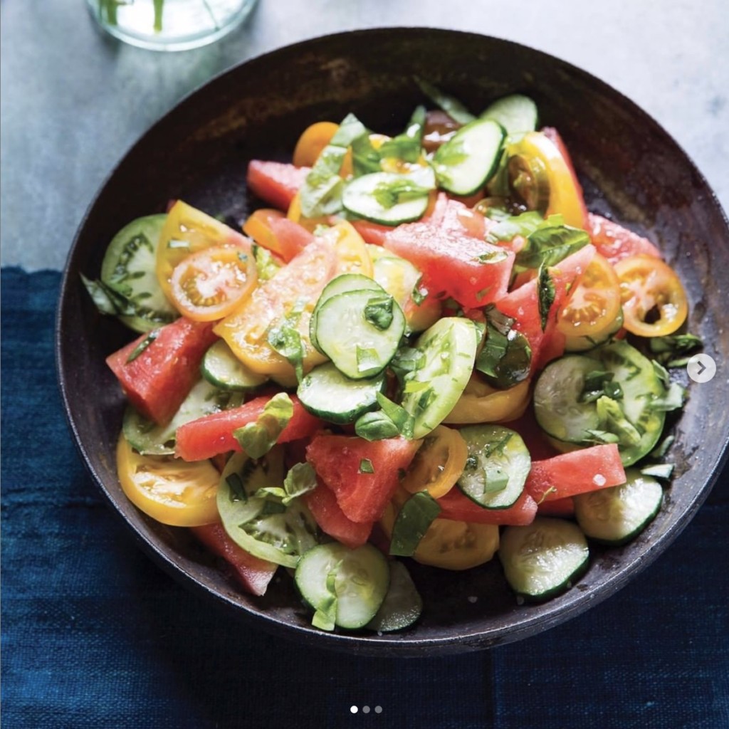 colorful heirloom tomatoes and cucumbers salad in a rustic bowl