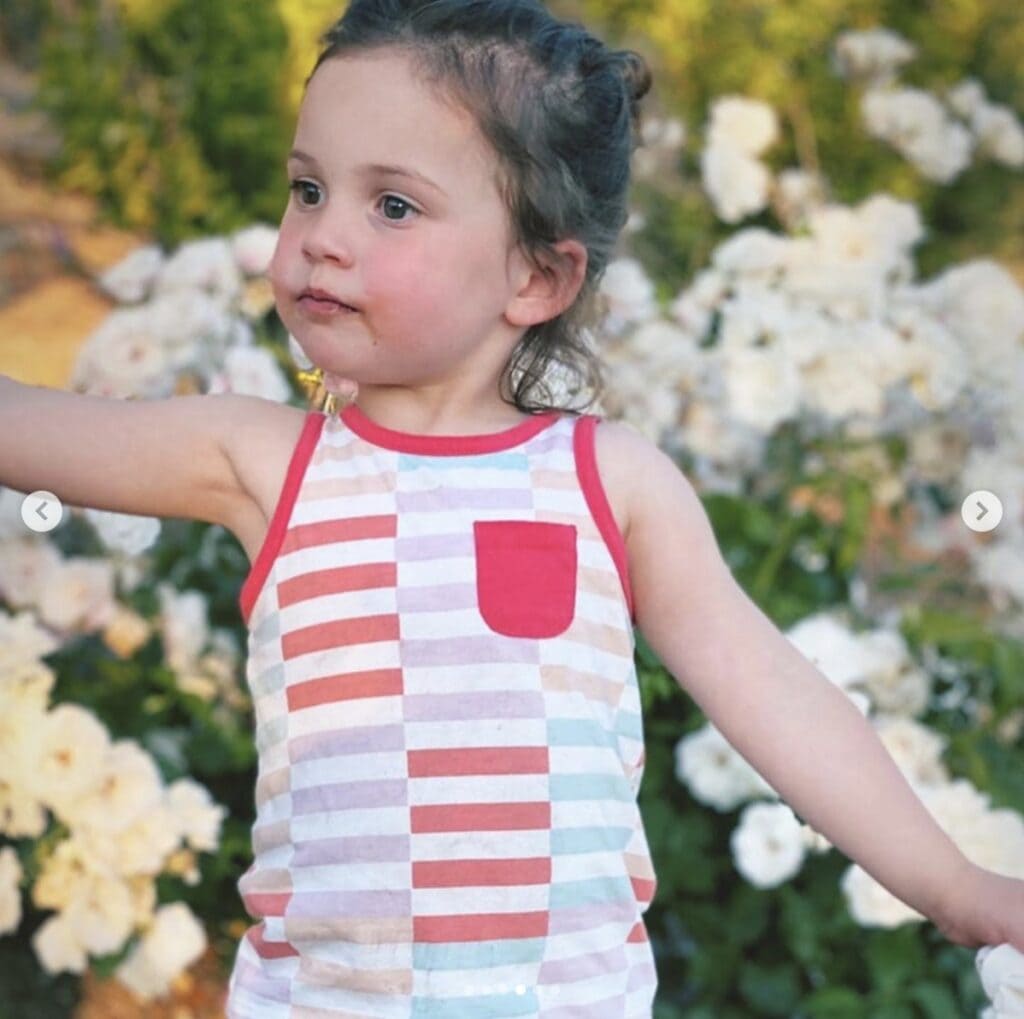 Picture of young girl wearing a striped tank top looking off camera