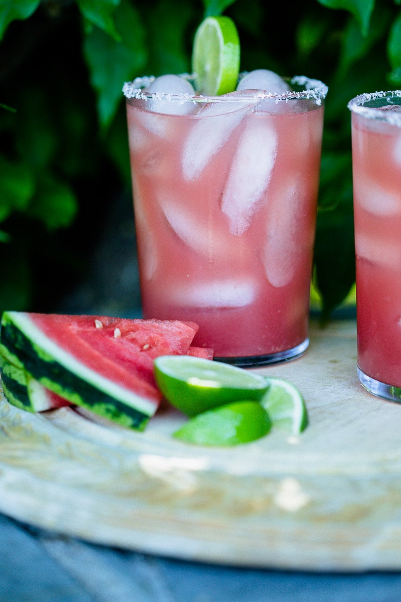 Watermelon Margaritas (Paleo & Refined Sugar-Free) served in glass tumblers full of ice and garnished with a lime next pieces of fresh watermelon and slices of lime